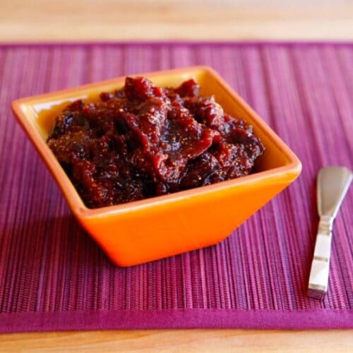 Fig Preserves on a small orange square-shaped bowl with a silver butter spreader knife