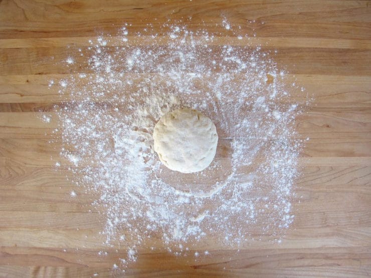 Ball of kneaded dough on a cutting board.