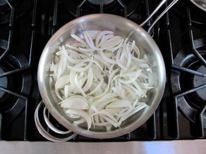 Sliced onions in a saucepan.