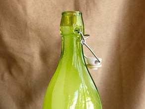 Fizzy ginger beer in green glass bottle, close up.