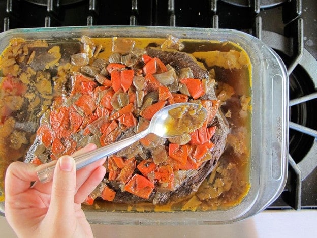 Spooning gelled fat out of roasting dish.