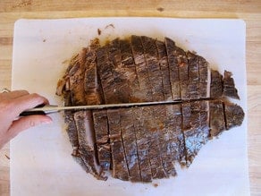 Cutting beef brisket in half.