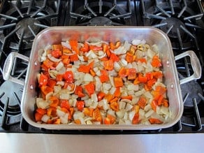 Diced carrots and peppers in a roasting dish.