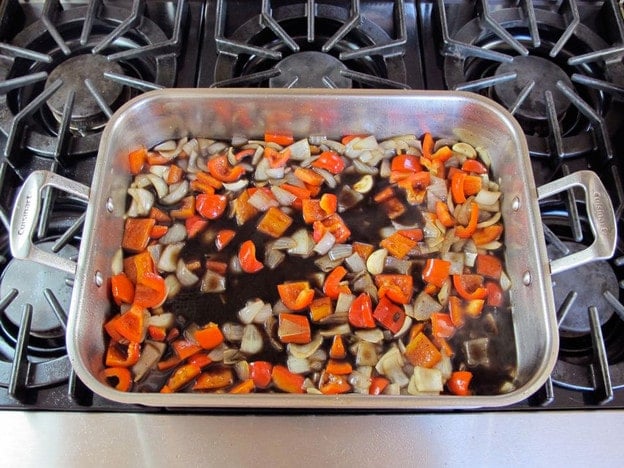 Coffee and rum added to vegetables in roasting dish.