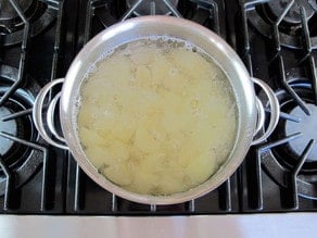 Peeled, diced potatoes in a stock pot of water.