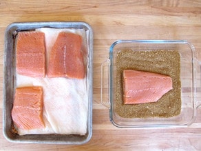 Salmon fillets on a lined baking sheet.