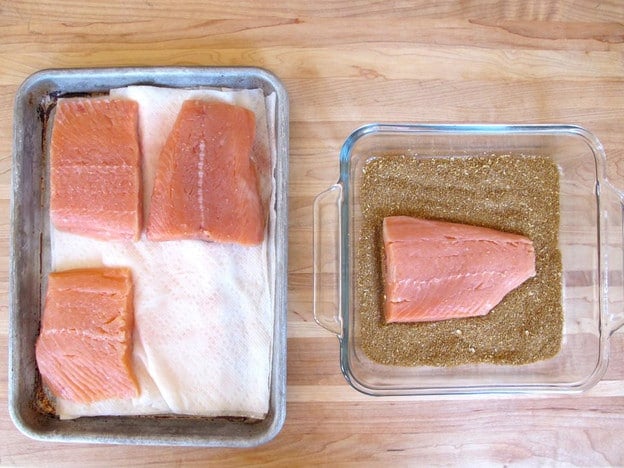 Salmon fillets on a lined baking sheet.