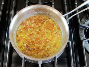 Chopped nuts added to melted butter in a pot.