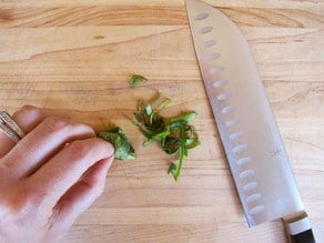 Chiffonade of basil on a cutting board.