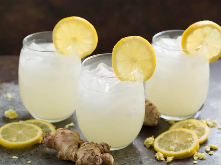 Three glasses of homemade ginger beer with lemon and ginger