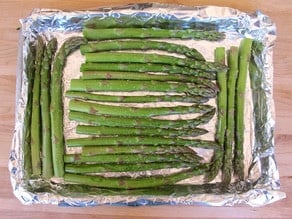 Asparagus on a lined baking sheet.