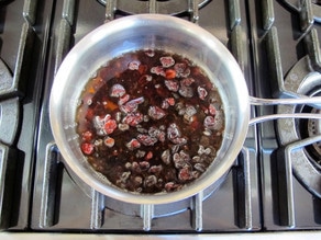 Dried fruit soaking in rum in a small pot.