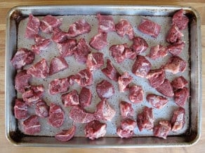 Lamb meat chunks on a baking sheet.