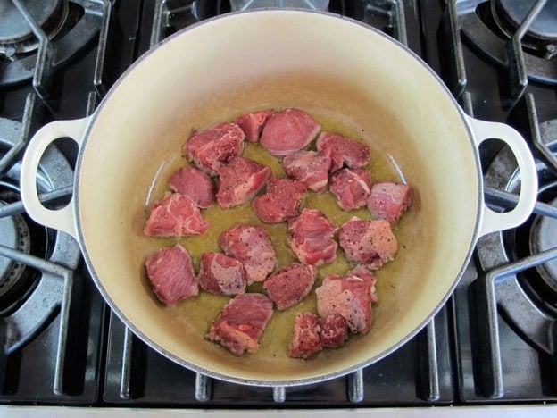 Browning lamb chunks in a stockpot.