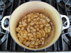 Browning potatoes and onions in a stockpot.
