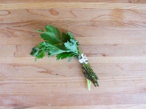 Herb bouquet on a cutting board.