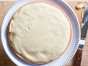 Spreading filling over a round cake layer.
