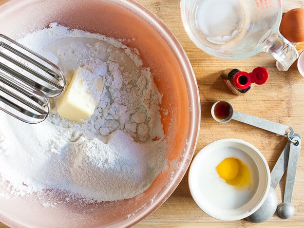 Add butter to dry cake ingredients in a large mixing bowl.