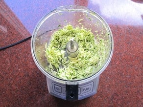 Grating zucchini in a food processor.