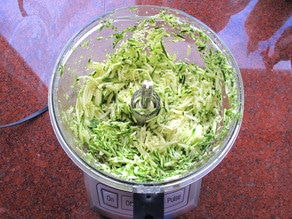 Shredded zucchini in a food processor.