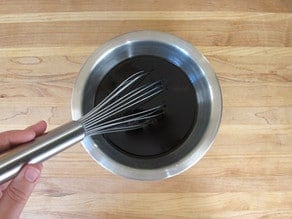 Whisking marinade in a small bowl.