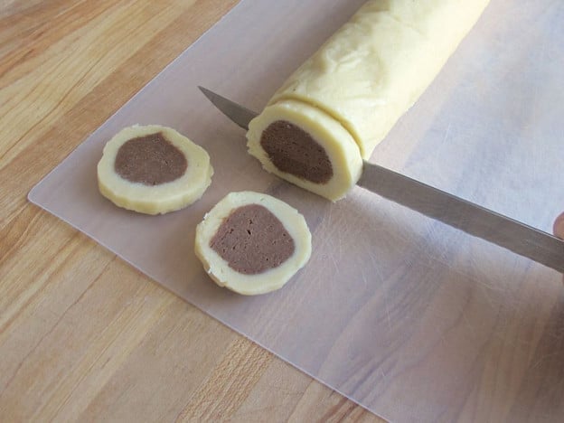 Slice chilled dough logs 1/8 inch thick.