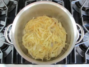 Sliced onions in a stockpot.