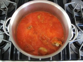 Paprikash sauce poured over chicken pieces in stockpot.