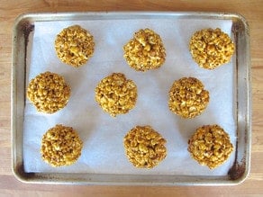Popcorn balls on a lined baking sheet. to dry.