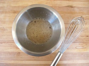 Egg whites whisked in a bowl until frothy.