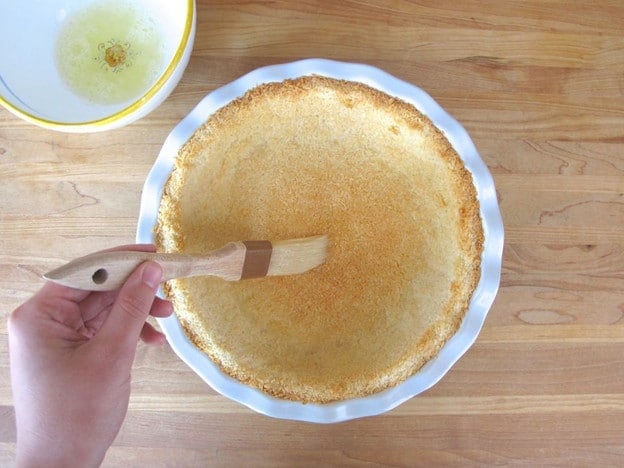 Brush par-baked crust with egg whites.