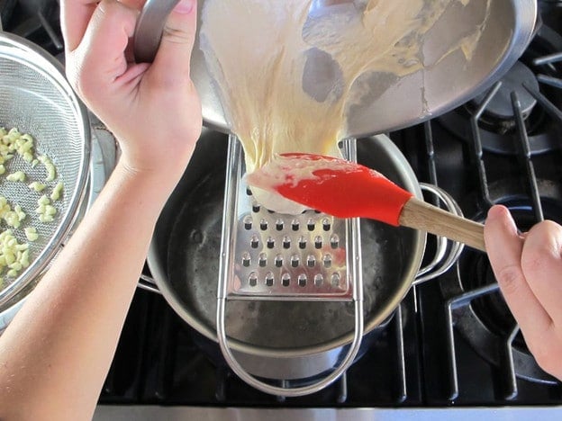 Pour batter through holes of a grater.