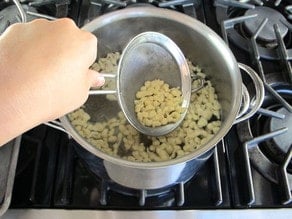 Strain cooked spaetzle with a mesh strainer.