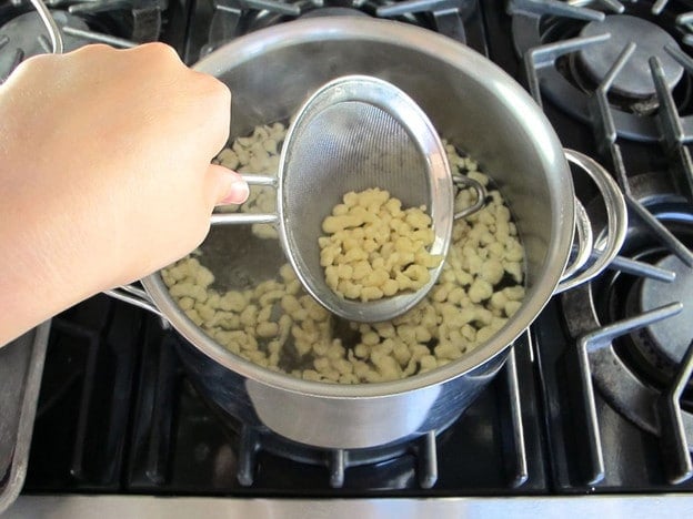 Strain cooked spaetzle with a mesh strainer.