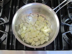 Sauteeing diced onions in a skillet.