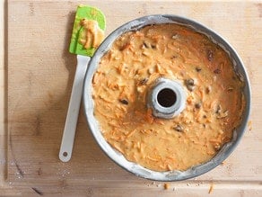 Carrot cake batter spread into bundt pan.