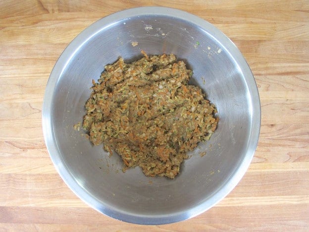 Add breadcrumbs to grated vegetables and combine with hands.