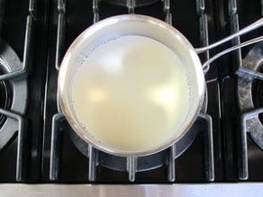 Heating milk in a small pot.