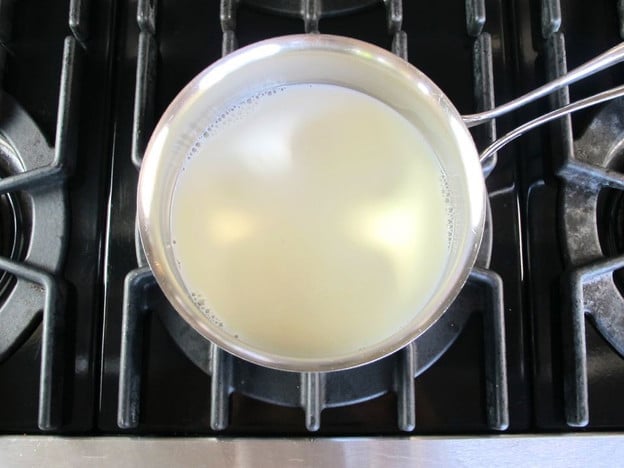 Heating milk in a small pot.