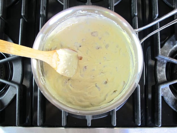 Melting cheese into white sauce.