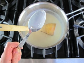 Stirring milk into a roux.