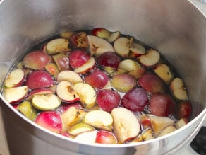 Quartered apples in a large stockpot of water.