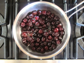 Heating cherries and coffee in a saucepan.