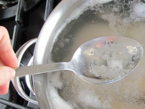 Skimming the foam from boiling chicken.