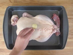 Rubbing duck with crushed garlic clove.