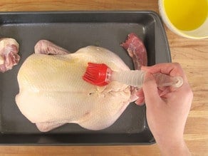 Brushing duck with melted butter.