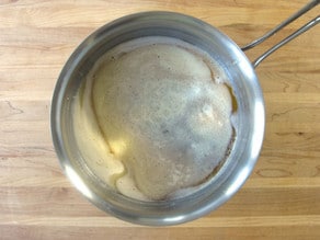 Stirring brown butter into sugar.