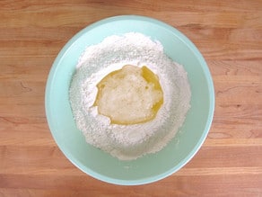 Stirring egg whites into powdered sugar.