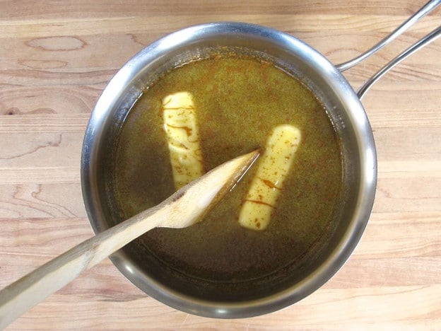 Melting butter into hot molasses.