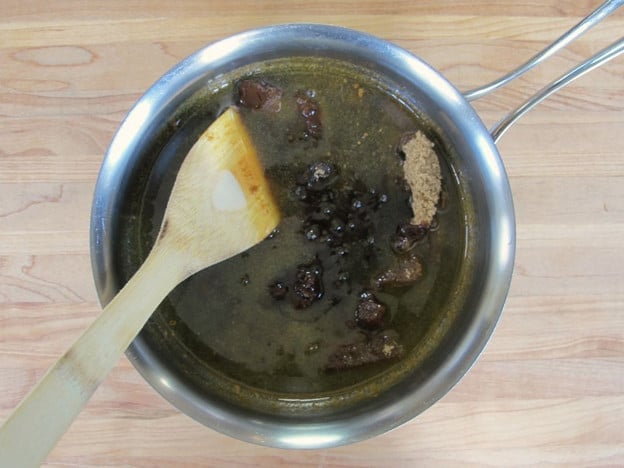 Stirring brown sugar into melted butter.